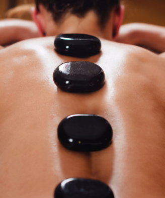 Massage therapist giving a client hot stone massage